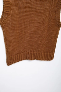 Close-up of caramel knit vest hem featuring thick ribbed texture and premium fabric details