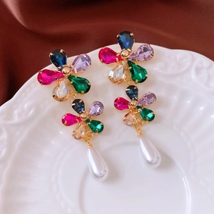 Détail de boucles d'oreilles vintage plaquées or 18k avec pierres colorées et perle