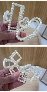Detailed view of large pearl hair claw clips in rectangular and heart shapes with gold spring