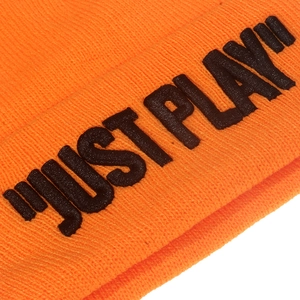 Macro detail of bright orange knit beanie showing texture and JUST PLAY embroidery