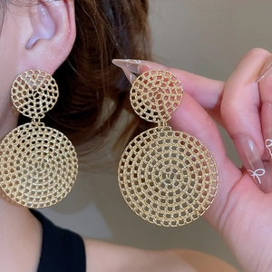 Detailed view of large gold hollow woven mesh hoop earrings worn for fashion style