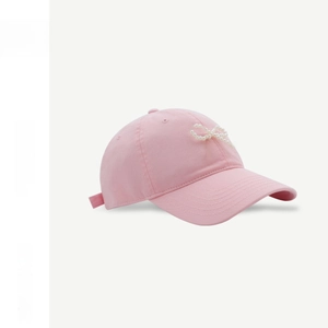 Detail of pink cotton baseball cap featuring exquisite pearl bow and adjustable strap