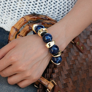 Detail of bohemian thick chain bracelet with blue marble beads and irregular gold spacers
