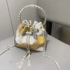 Dettaglio della borsa a secchiello con strass, manico in metallo e coulisse con nappe