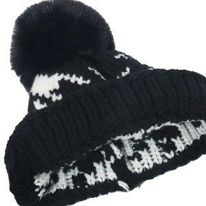 Classic black and white houndstooth knit beanie with a large faux fur pompom for winter