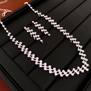 Detail view of silver geometric rhinestone jewelry set with necklace and earrings on a tray