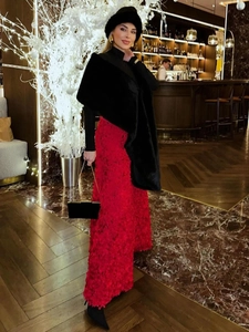 Detail view of luxury red textured petal skirt paired with black faux fur shawl