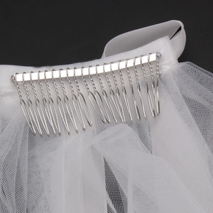 Detailed macro view of white tulle bridal veil with secure metal hair comb attachment