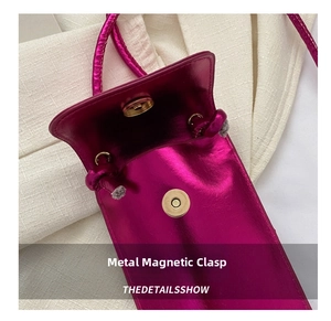 Détail du sac à bandoulière rose métallisé montrant le fermoir magnétique doré