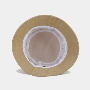 Detailed interior of beige cotton bucket hat with breathable white mesh lining and stitching