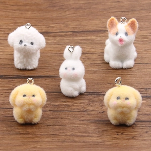 Charming flocked resin cartoon puppy and bunny pendants on a dark wooden background
