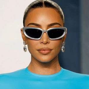 Close-up of silver futuristic sports sunglasses and crystal earrings on a model