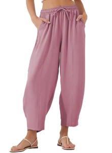 Vue détaillée du cordon de serrage élastique et des poches latérales du pantalon rose