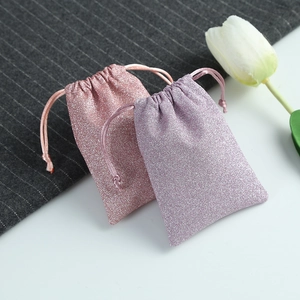 Close-up of pink and lavender glitter drawstring jewelry pouches with tulip accent