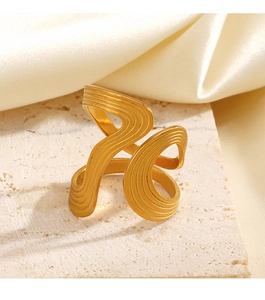 Detailed view of the gold irregular wavy texture on the thick geometric metal ring