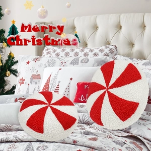 Detail of two round red and white peppermint candy pillows with fluffy sherpa texture