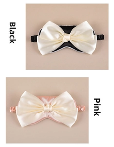 Detail view of silk texture sleep masks in black and pink with large bow decorations
