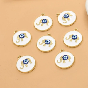Detailed macro of golden elephant charms with blue evil eye enamel for DIY jewelry
