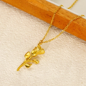 Détail d'un collier pendentif rose dorée élégant sur une surface texturée minimaliste