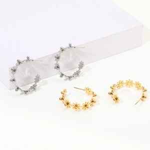 Detailed view of C-shaped titanium steel floral earrings in gold and silver finishes