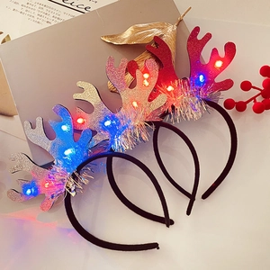 Close-up of LED Christmas headband with glitter reindeer antlers and festive glowing beads