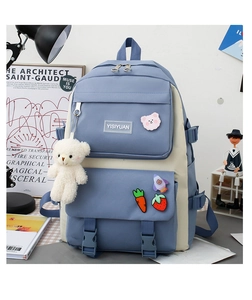 Detail of blue and beige canvas backpack with teddy bear pendant and cute decorative pins