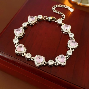 Makro-Detail von Silberarmband mit rosa Herz-Zirkonia und runden Kristallen