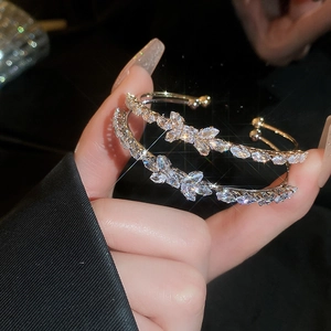 Close-up of golden zircon bow bracelets with sparkling crystal stones in soft lighting