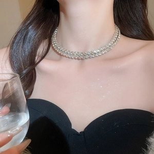 Detail of elegant silver double-layer rhinestone necklace on model with shimmering finish