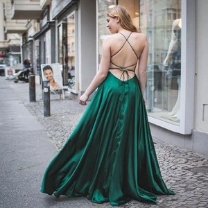 Elegant emerald green satin evening gown featuring an open back with lace-up straps
