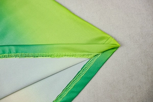 Close-up detail of overlock stitching and green-yellow gradient fabric fibers