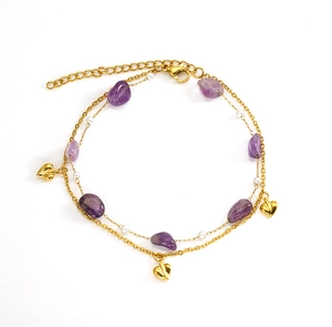 Detail of double-layer gold anklet with purple stones, white beads and heart charms