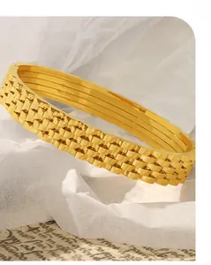 Close-up of gold plated stainless steel bracelet with textured watchband style layers