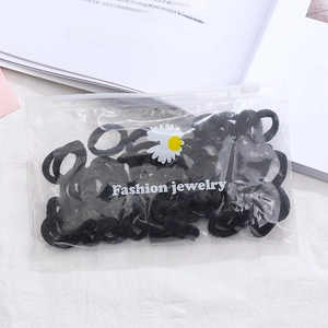 Detail view of black high-elastic hair ties in a daisy frosted zipper bag packaging
