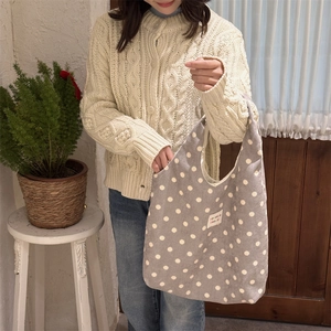 Close-up of a gray polka dot canvas tote bag with a white sorakka beaute label