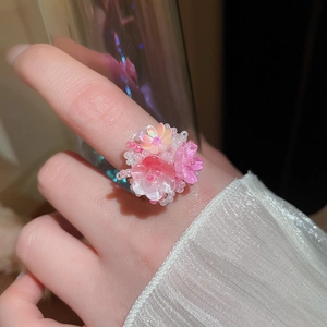 Dettaglio dell'anello a fiore in acrilico con petali rosa e perline di perle