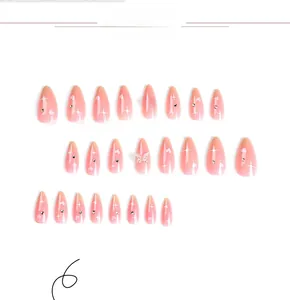 Detail of pink gradient press-on nails with white hearts, stars, and silver butterfly rhinestones