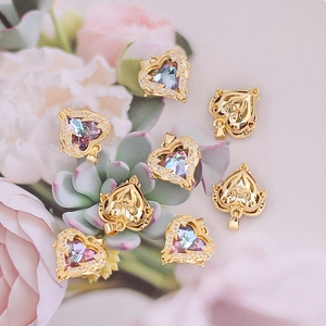 Golden heart and fox pendants with colorful stones on succulents background