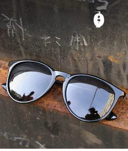 Close-up of black retro cat-eye sunglasses with gray lenses on industrial metal texture
