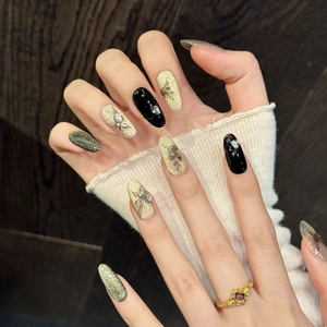 Handmade almond press-on nails with black rose patterns, gold glitter and butterfly charms