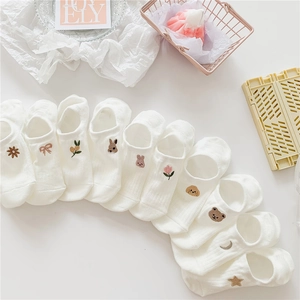 Detailed view of ten pairs of white cotton no-show socks with delicate animal embroidery
