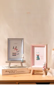 Detail of wooden cartoon bunny photo frames in blue and pink with cute rabbit figurines