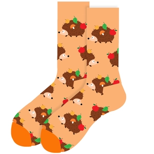 Detail view of orange cotton socks with cartoon hedgehog, apple and mushroom patterns