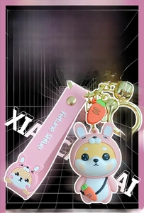 Close-up of cute Shiba Inu keychain in rabbit costume with pink silicone strap