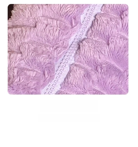 Detailed macro view of smooth purple zipper track on soft plush checkered cosmetic bag