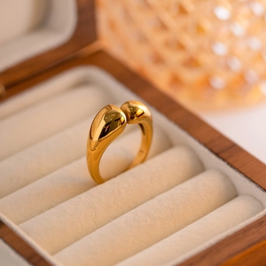 Detailed view of teardrop shaped gold stainless steel open ring displayed in a box
