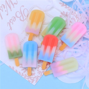 Macro shot of colorful resin miniature ice cream and popsicle charms on light blue background