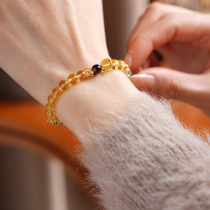 Detailed close-up of beaded flower bracelet featuring yellow citrine and garnet stones