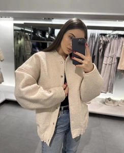 Detailed texture of beige fuzzy oversized jacket featuring silver button closures