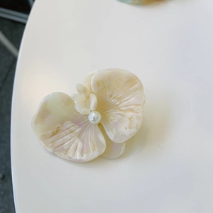 Elegant off-white orchid hair clip with pearl center in high-quality acetate finish